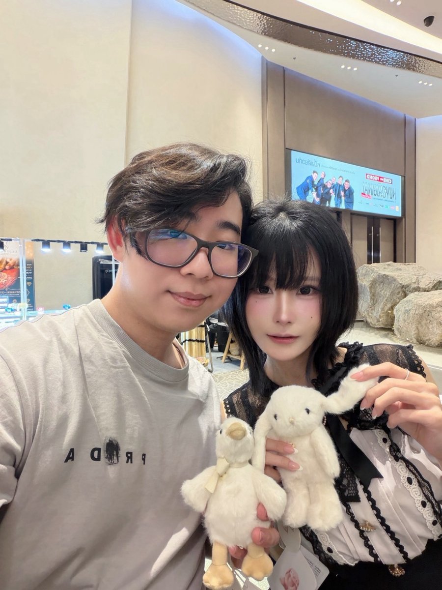 Holding a white duck and a white bunny plush