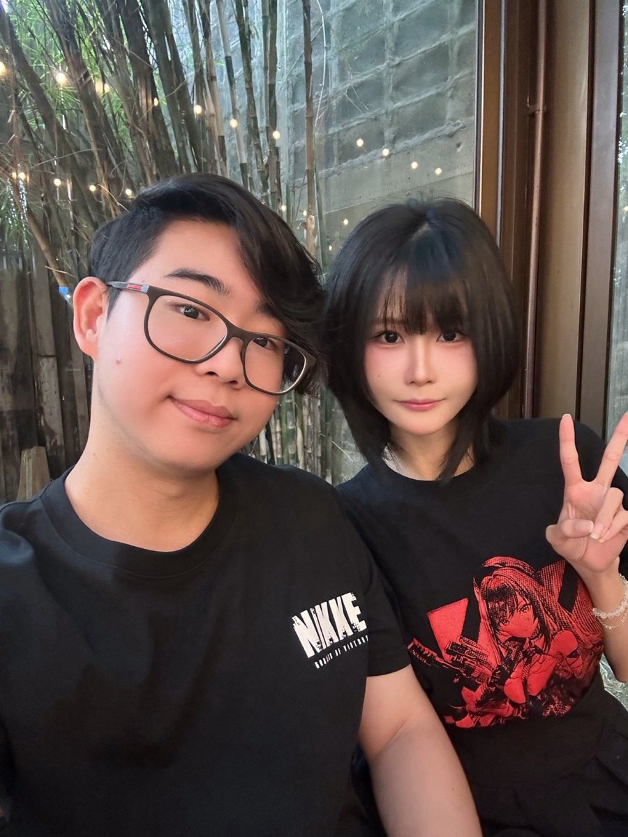 Matching NIKKE t-shirts by a bamboo window